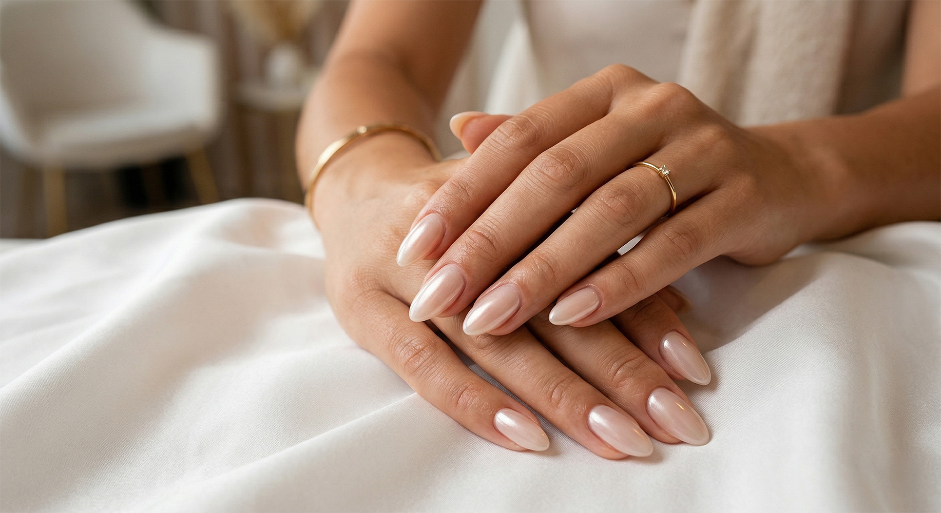 Eleganckie dłonie z minimalistycznym manicure quiet luxury na białym jedwabiu